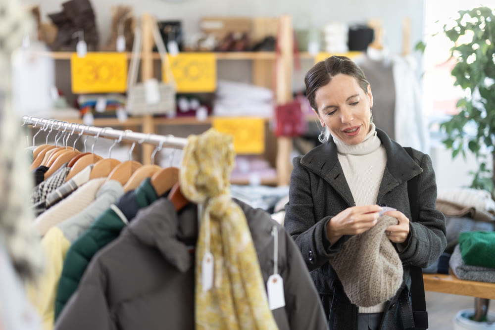 Adult woman choosing hat in clothing store