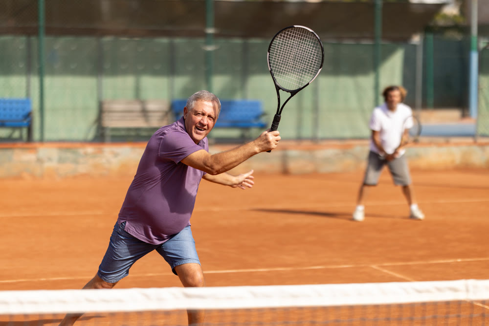 Two men playing lawn tennis outdoors