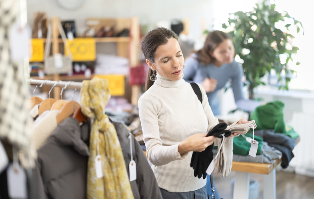 Woman carefully selects warm winter gloves in clothing store