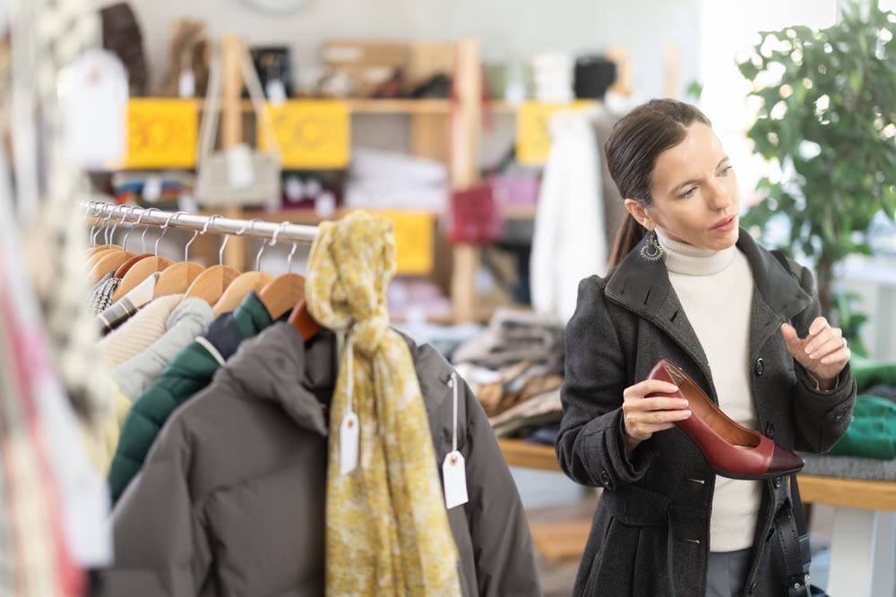 Happy woman chooses fashionable high-heeled shoes in shoe store