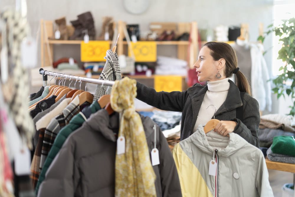 Preparing for fall and winter - woman chooses fall and winter clothes in store