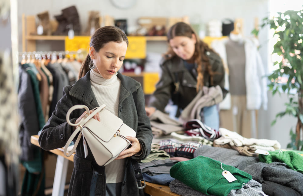 Woman chooses fashionable handbag in clothing boutique