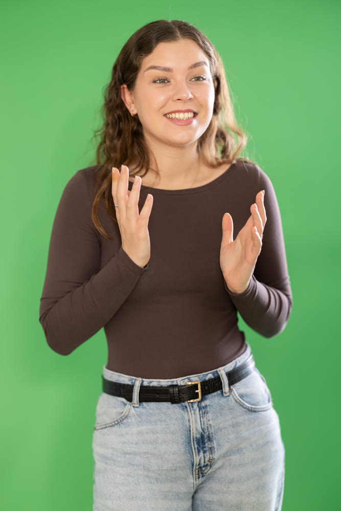 Portrait of girl expressing happy emotions on green background