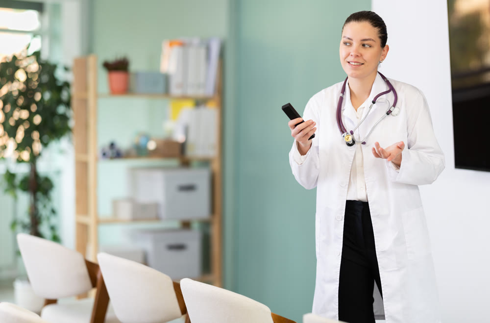 Girl doctor speaker with remote control during lecture
