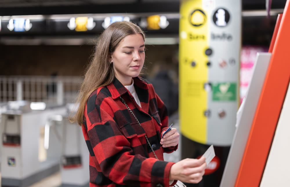woman pays for a subway ticket