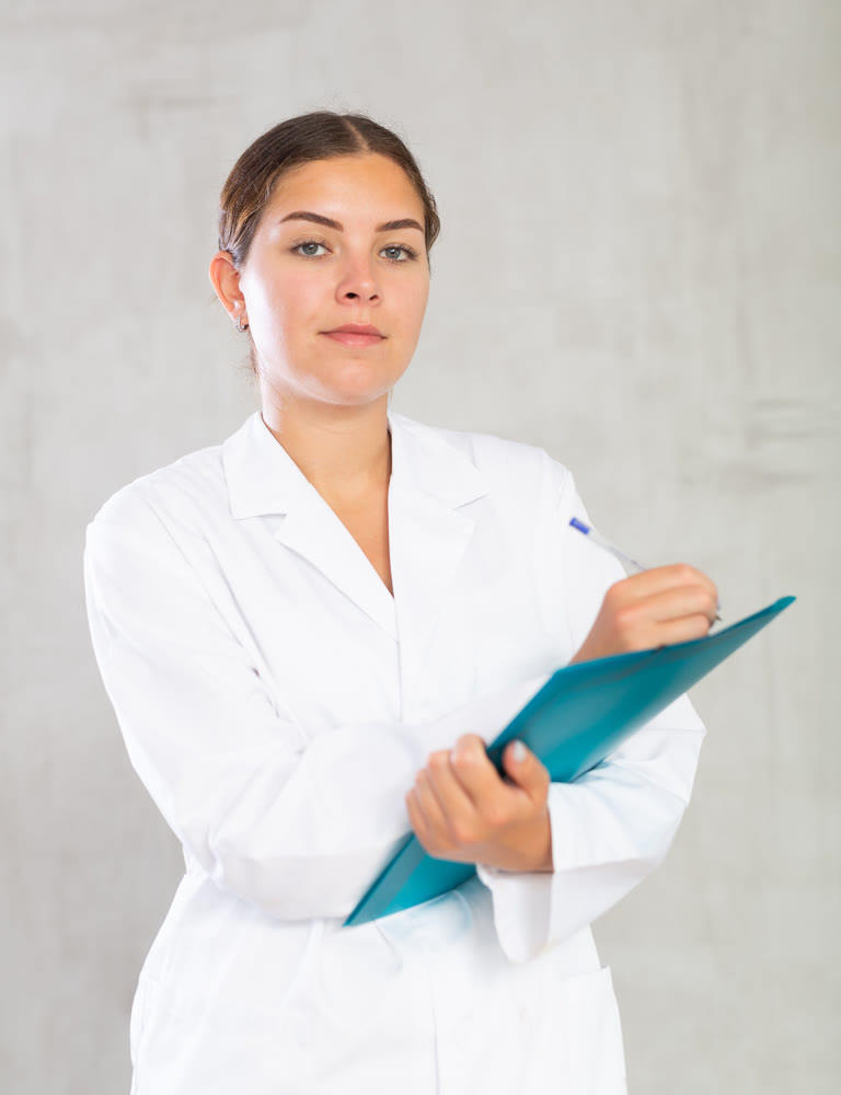 Female doctor makes notes in documents holding a folder of papers in her hands