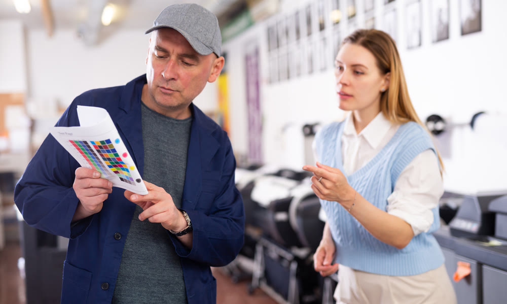 Man and woman printing office workers talking about job