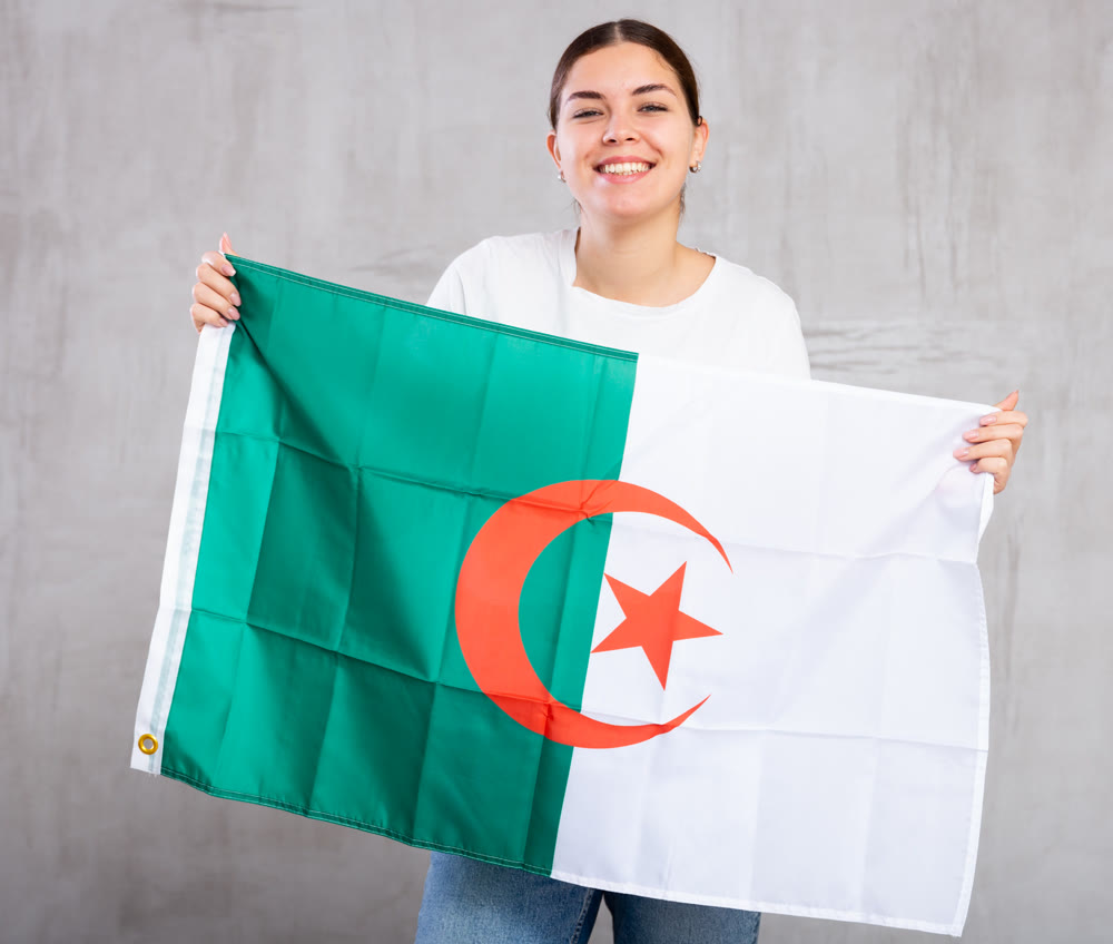 Portrait of positive young woman holding Algeria flag