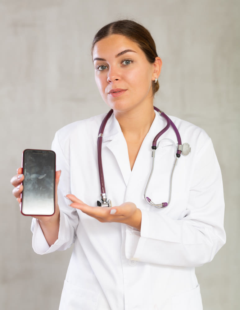 Young woman posing in medical uniform with phone