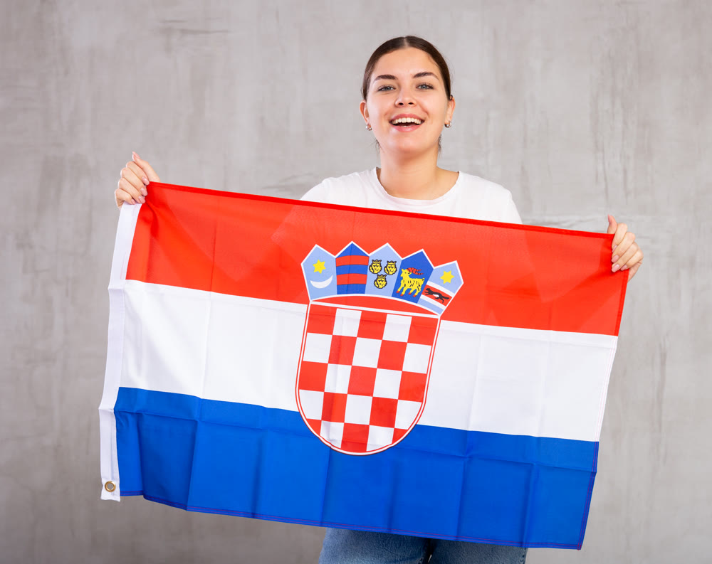 Smiling young woman holding Croatian flag