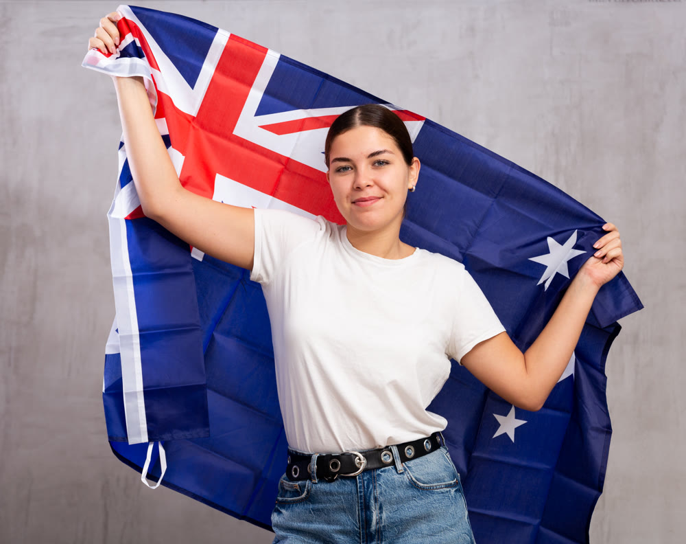 Happy girl stands with flag of Australia .Isolated