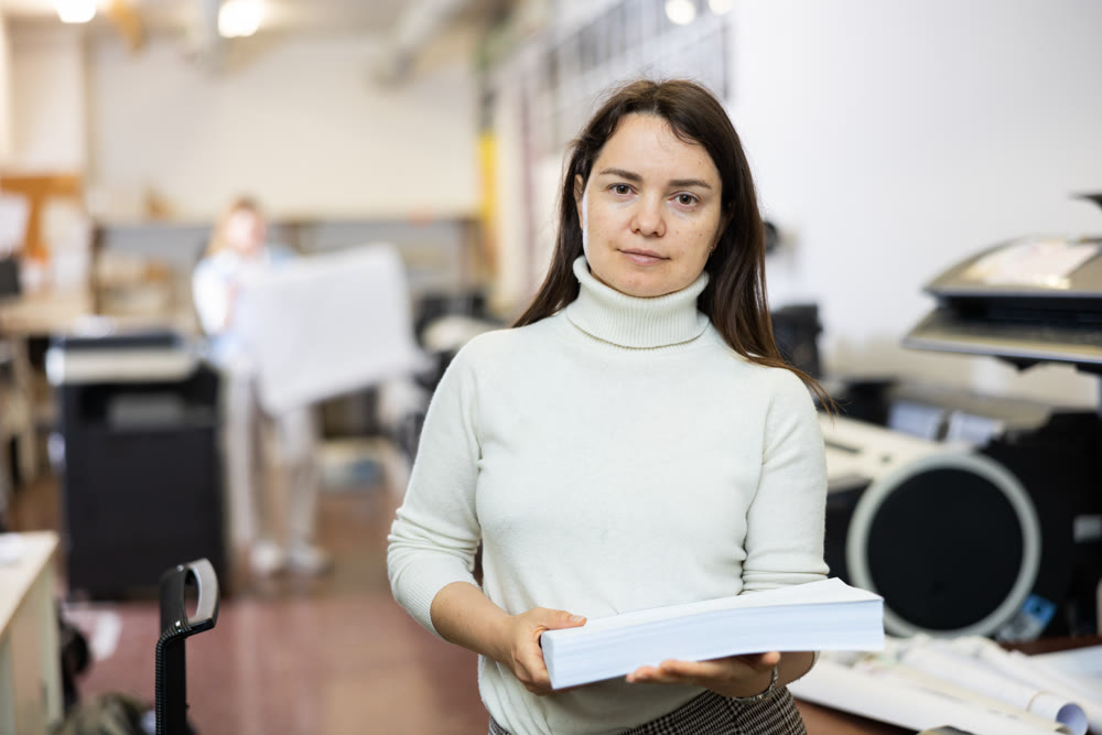 Portrait of happy woman with a stack of paper in her hands in typography