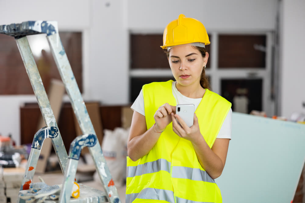 Woman builder talking on the phone - making an order for building materials on phone
