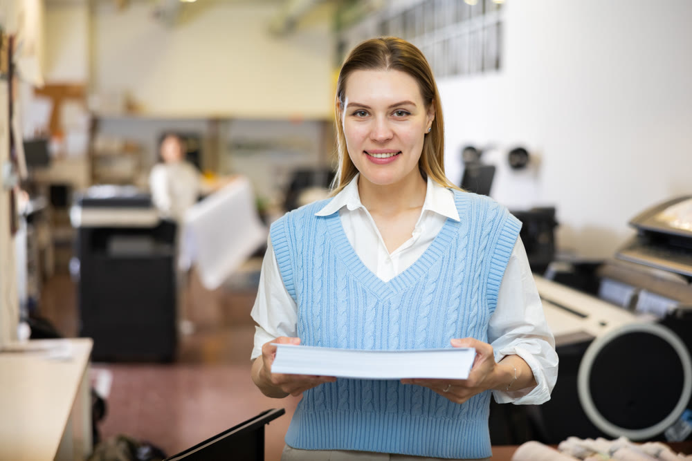 Portrait of happy woman with a stack of paper in her hands in typography
