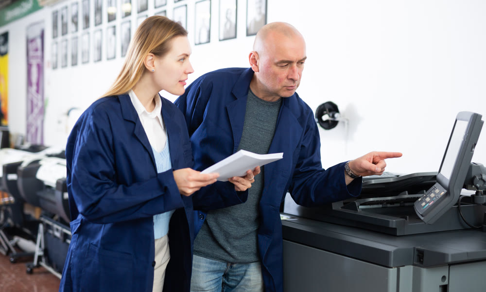 Service engineer conducts training on work on copiers of an office worker