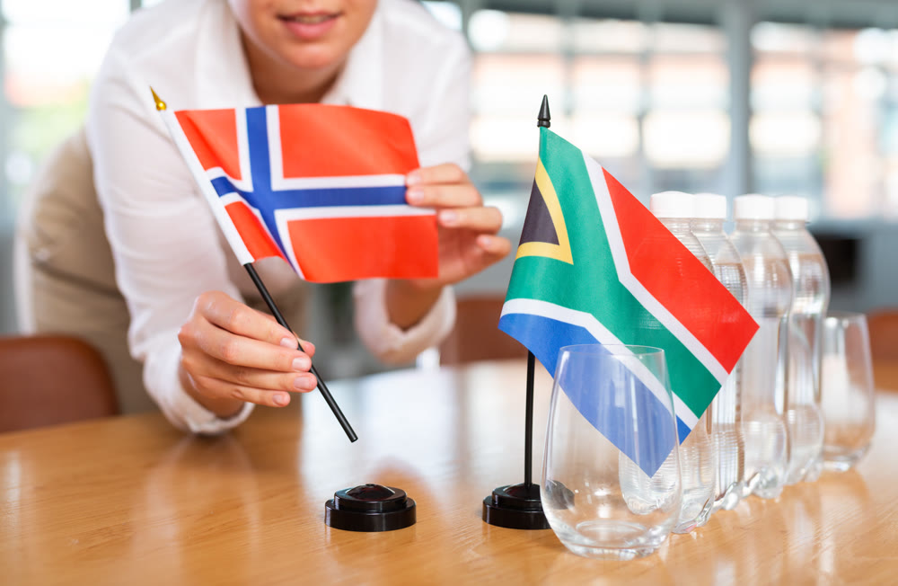Blurry girl set midget flags of South Africa and Norway before international negotiations