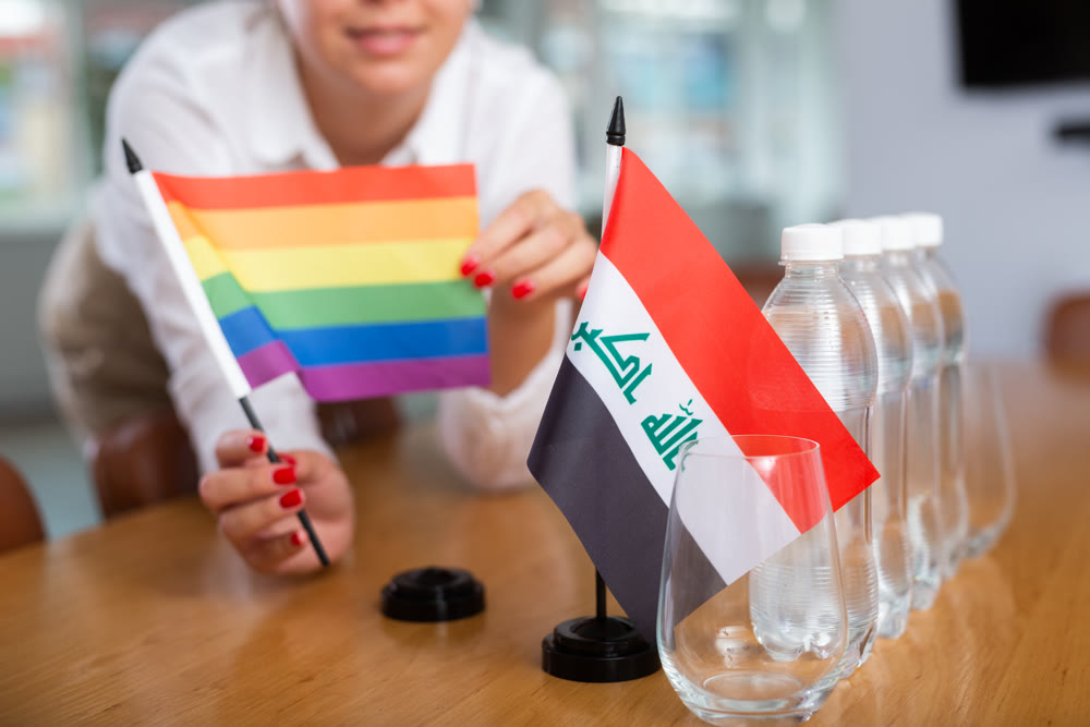 Unrecognizable girl sets midget Iraq and Pride flag before international negotiations