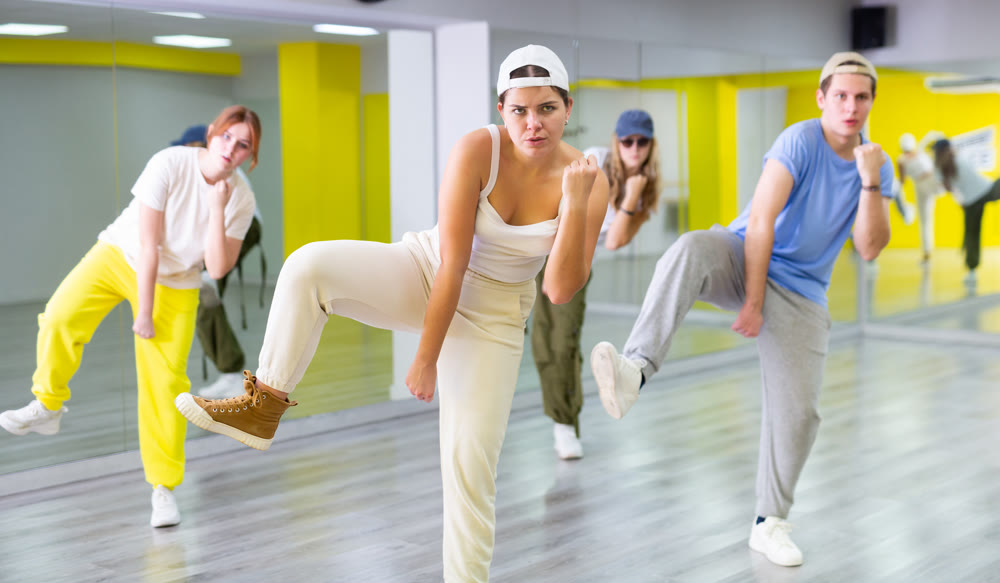 Teen girl exercising in group with friends during dance class
