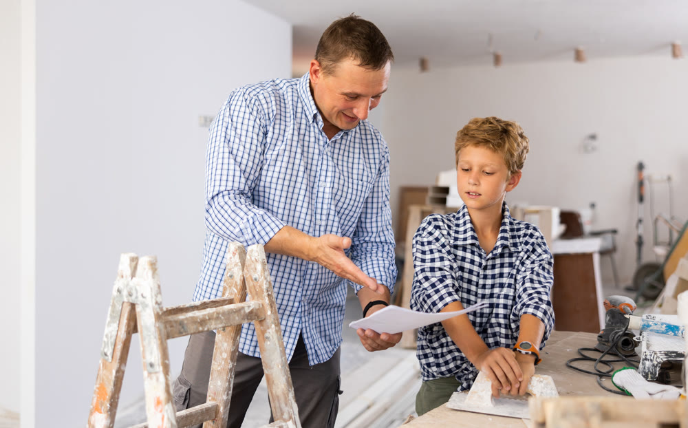 Father and his young son discussing work plan in construction site