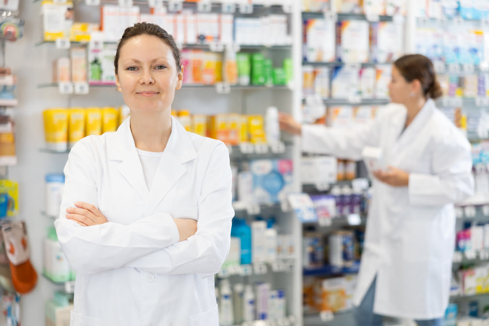 At pharmacy, apothecary waiting for customers and invites with gesture go to department of cosmetics
