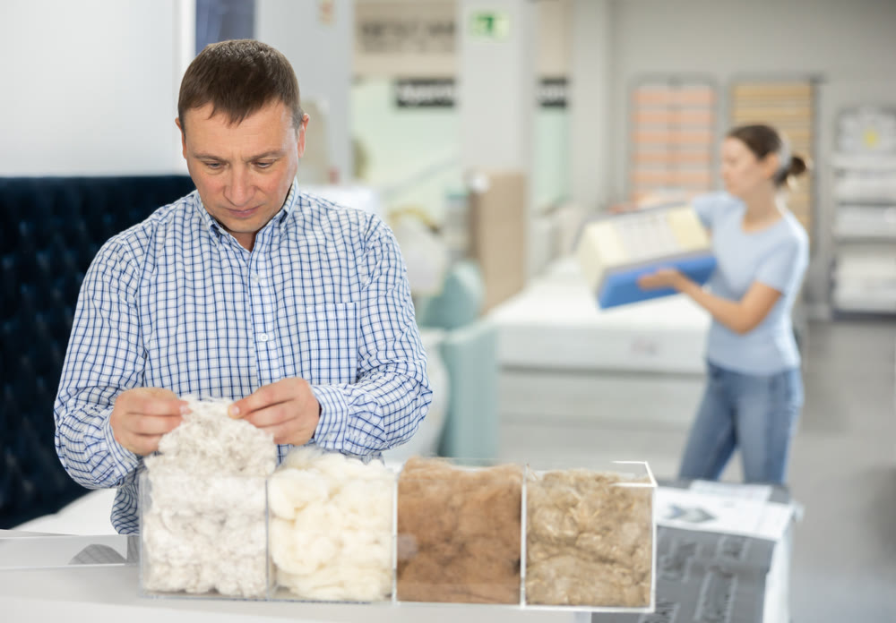 Man chooses mattress filling in furniture store