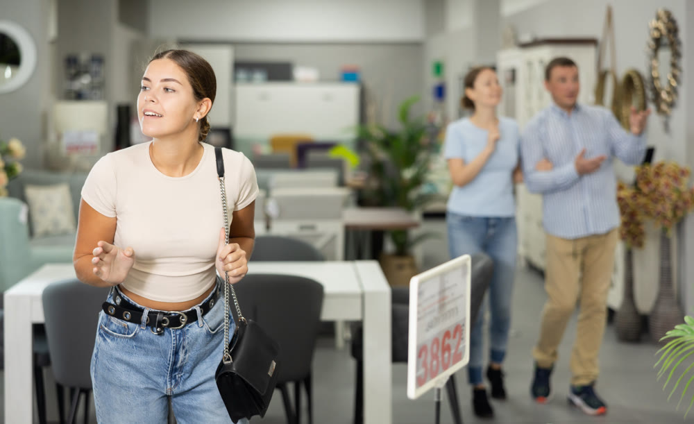 Girls eyes scan room furniture store, searching for perfect item to complete living space
