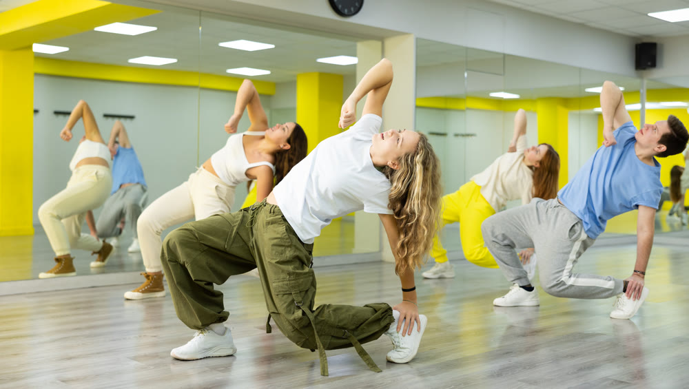 Joyous boy and girls dancing hip hop at lesson in class