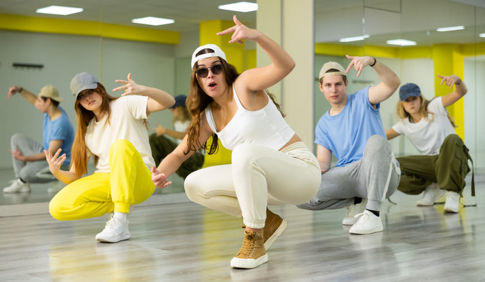Young girl sitting in breakdance pose in dance hall