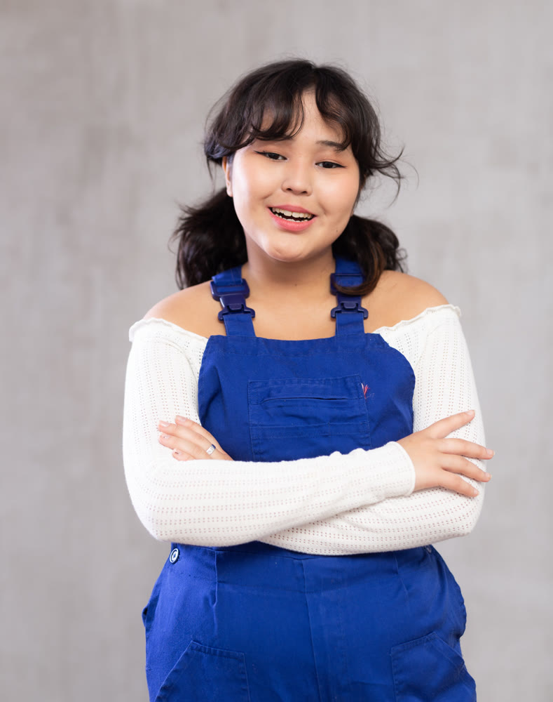 Portrait of positive smiling girl in blue protective overalls