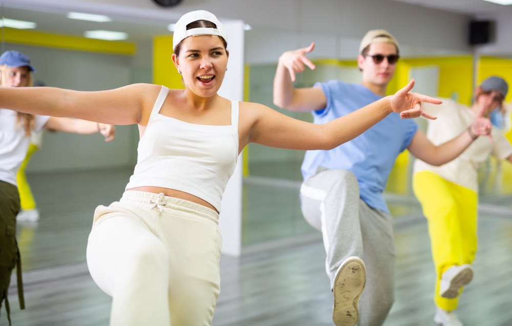 Young girl in cap dancing hip hop