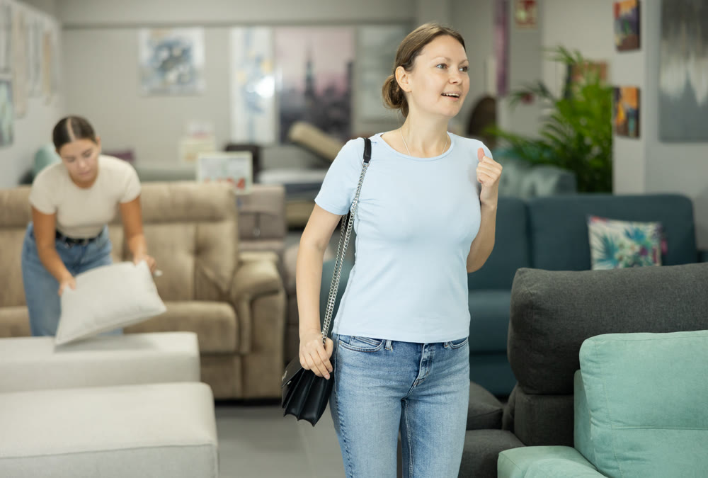 Interested woman choosing functional furniture for home in shop