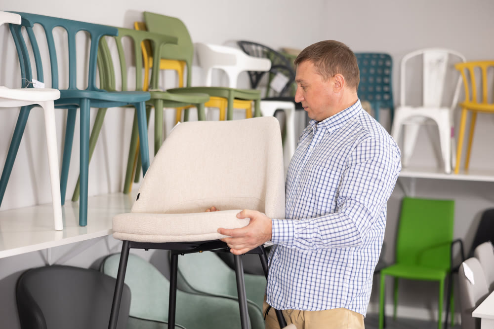 In furniture store, man considering choose chairs for completing office suite