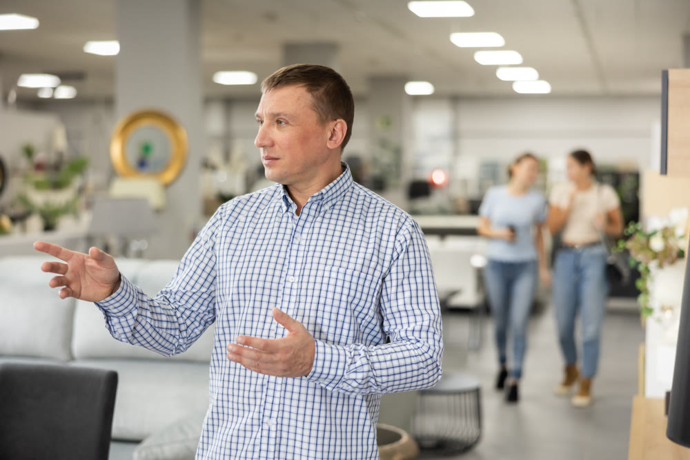 Mans eyes scan room furniture store, searching for perfect item to complete living space