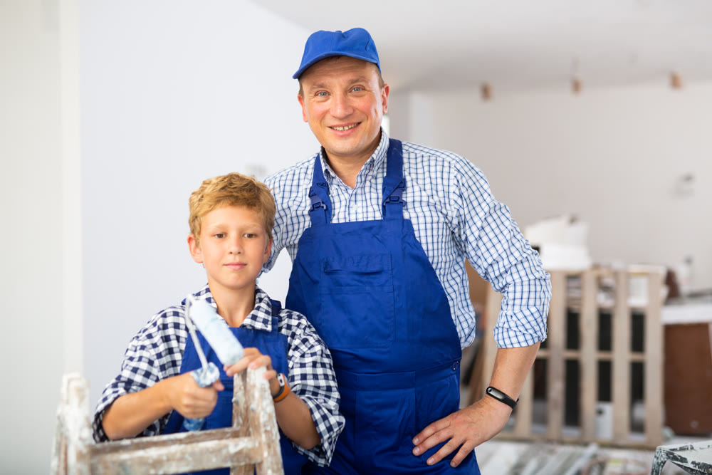 Boy with father holding renovating home tools