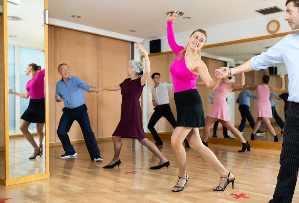 Couple of dancers rehearsing ballroom dances in dance studio
