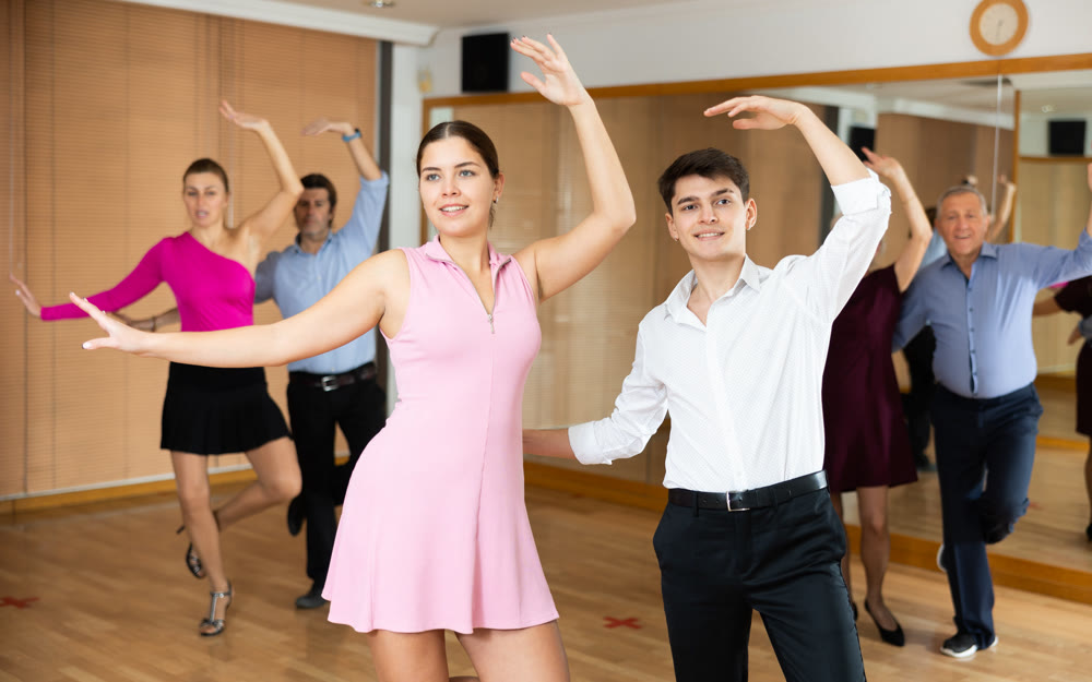 Young couple dancing jive during group training