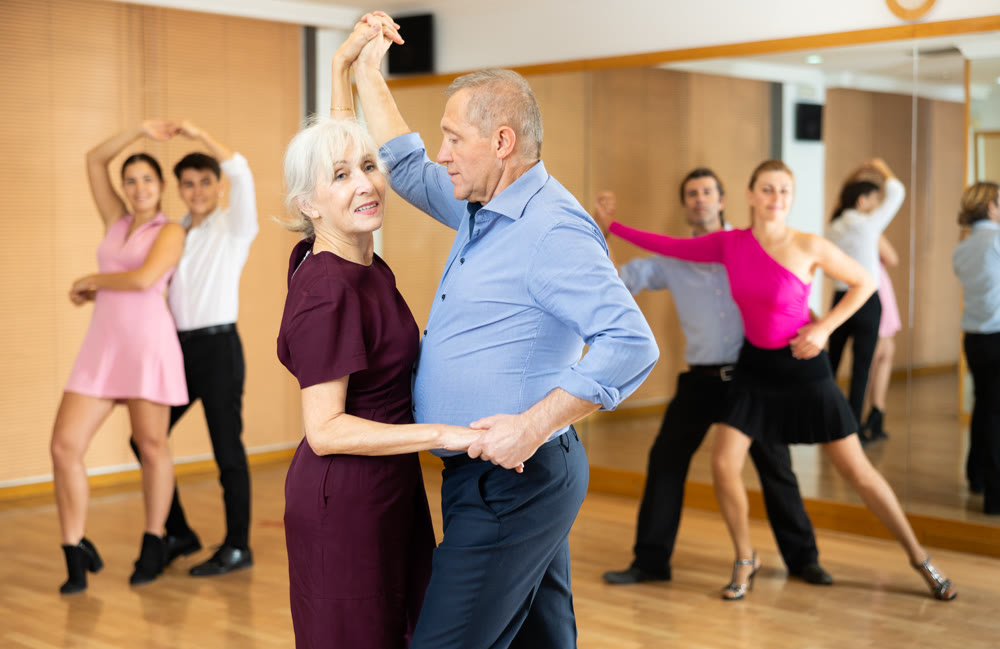 Couple of mature dancers rehearsing ballroom dances in dance studio