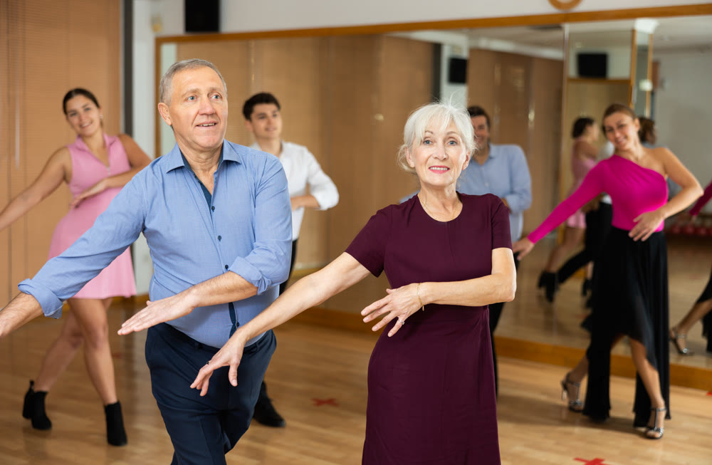 Couple of mature dancers rehearsing ballroom dances in dance studio