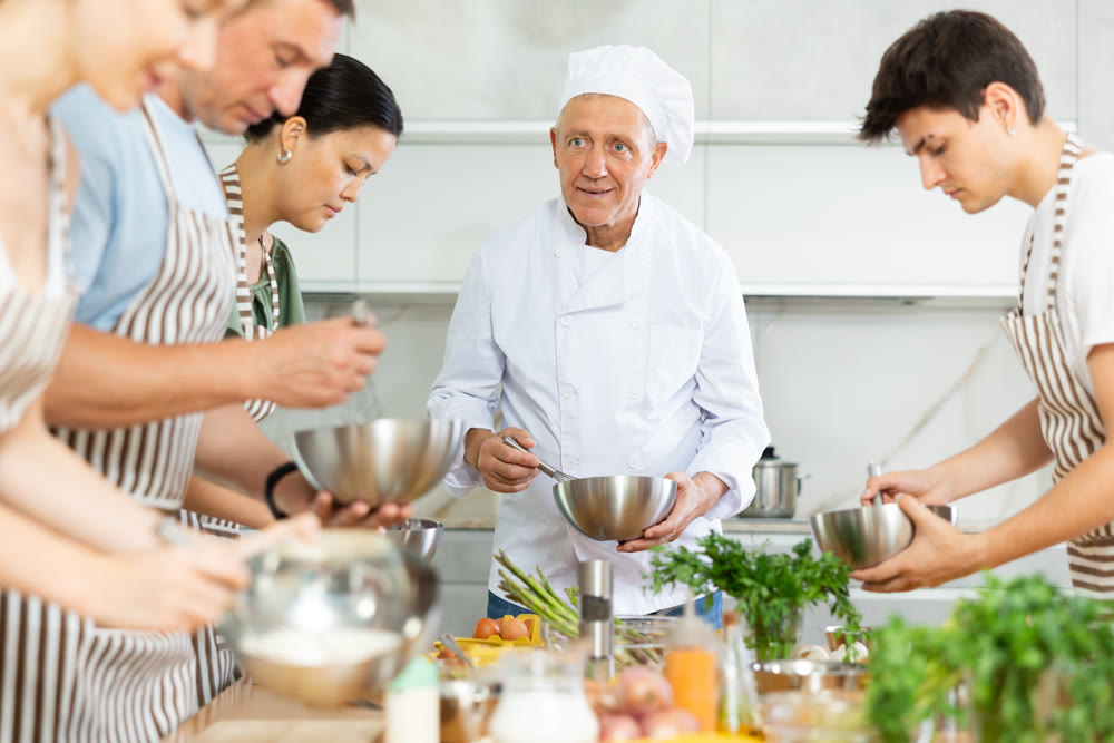 Chef teaches how to beat raw eggs with a whisk in cooking class