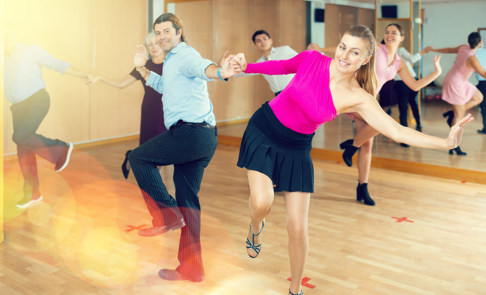 Happy couple performing a paired dance in ballroom