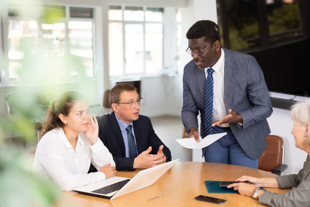 African man auditor speaks about trouble before meeting of frowning shareholders of businessmen