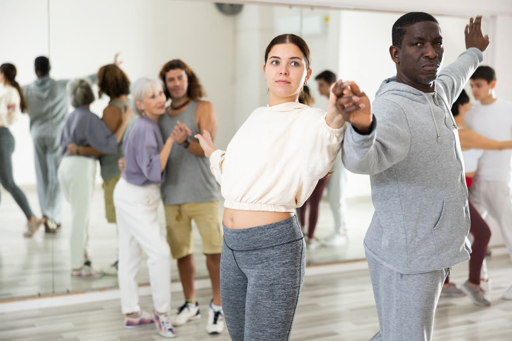 African man and caucasian young woman learning paired latin dances