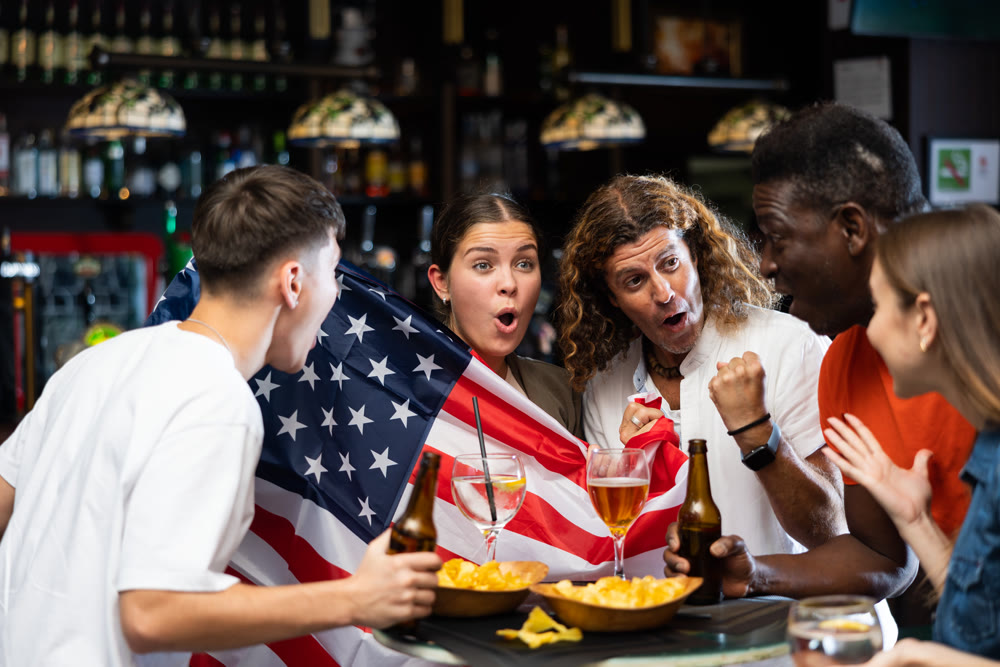 Group of American football fans cheering for favorite team in sports bar