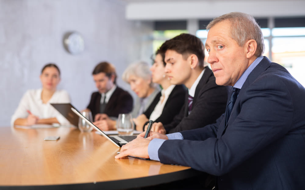 Group of businessmen attentively watching a presentation in meeting room