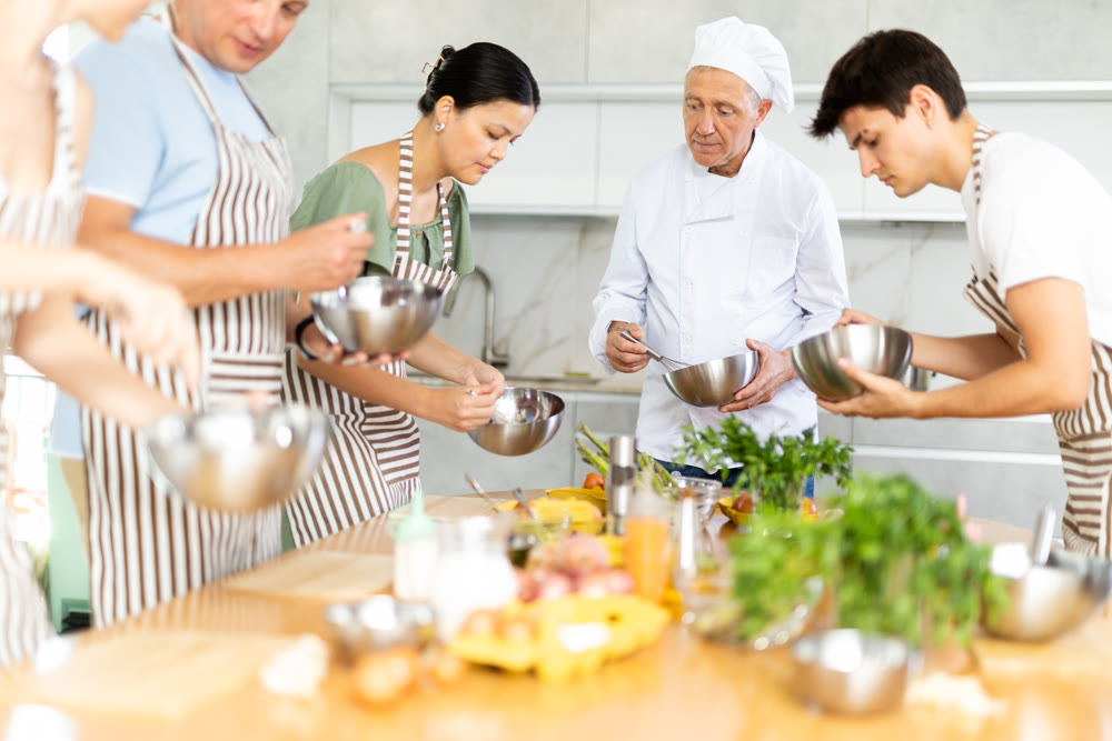 Chef apprentices learn how to properly beat eggs with a whisk in cooking class