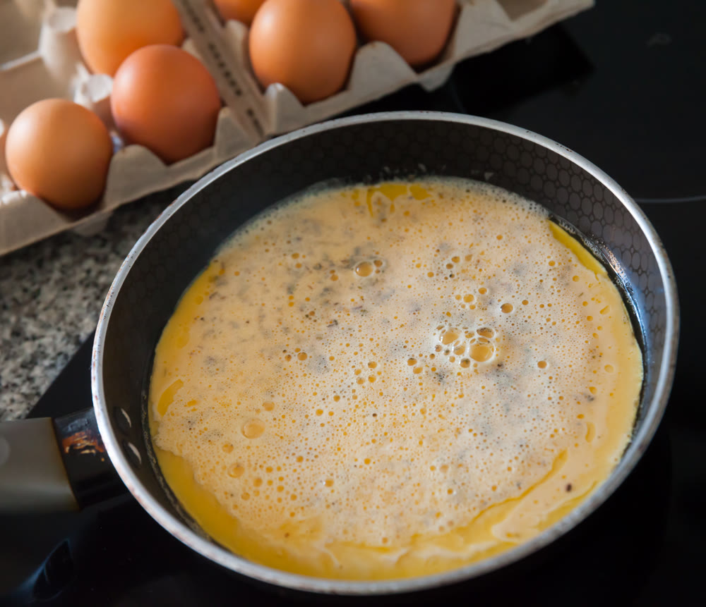 Cooking an omelette in frying pan for breakfast