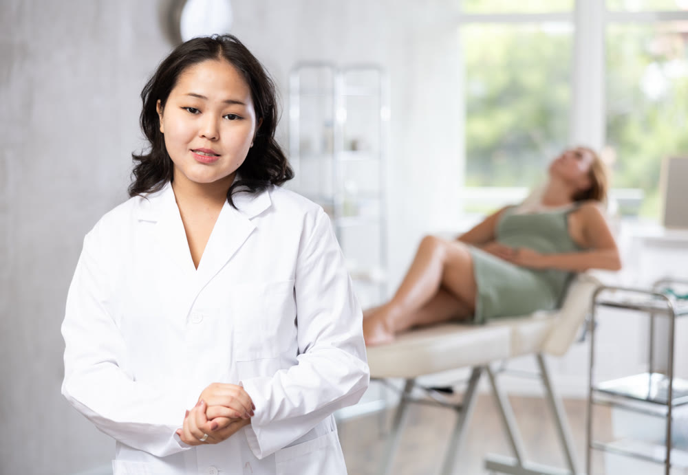 Portrait of female beautician in white coat at body aesthetics clinic