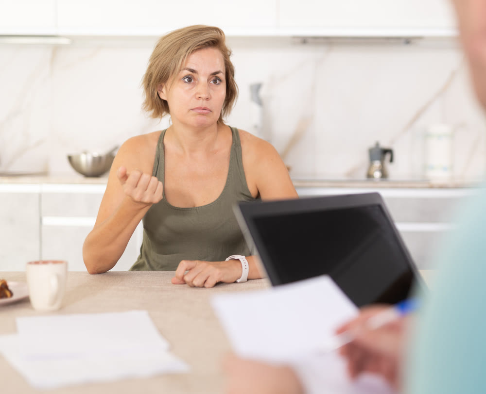 Adult woman discussing deal with salesman in kitchen