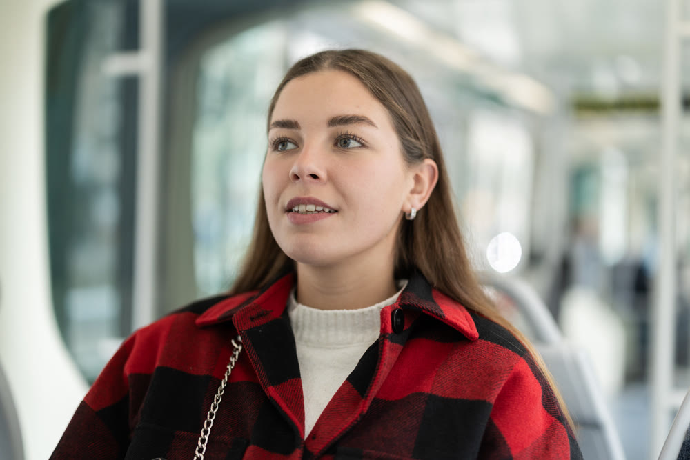 Young woman sitting in tram and looking away