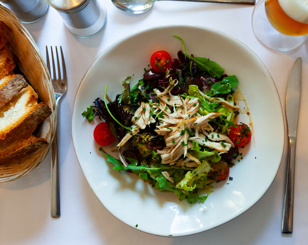 Tasty chicken salad with arugula and tomatoes at plate